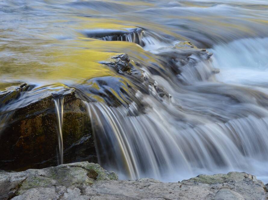 Flowing waterfall cascading over rocks at Upper McDonald Creek in a natural landscape